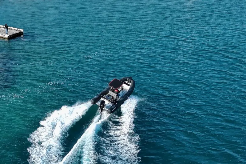 Slide: The Image of 2026 Northstar VEGA 6.4 boat cruising on clear blue water near a dock. - 8