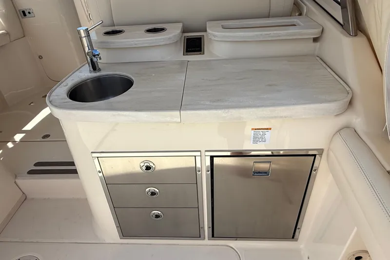 Slide: The Image of 2023 Grady-White Freedom 335 boat kitchenette with sink, storage, and stainless steel fixtures. - 19