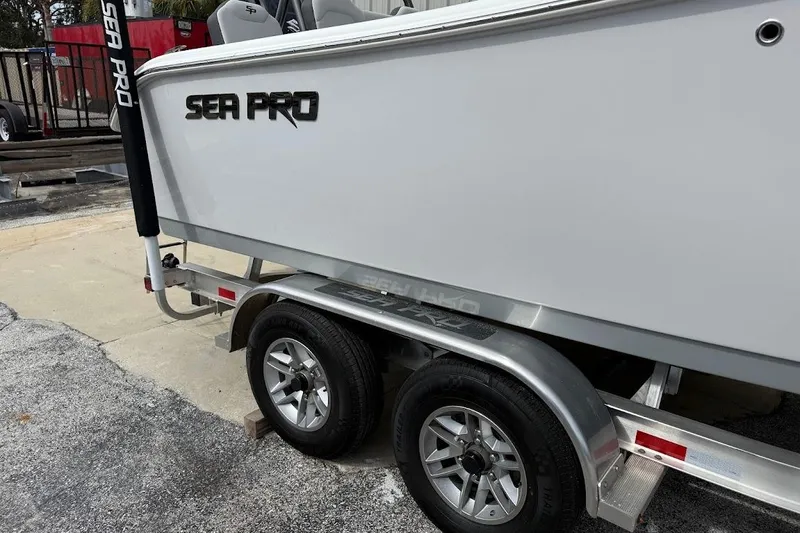 Slide: The Image of 2026 Sea Pro 245 Sandbar boat on trailer, showcasing sleek design and dual wheels. - 3