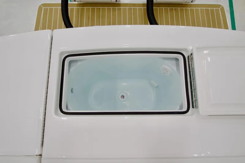 Slide: The Image of 2026 Regulator 28 boat livewell with open lid, showcasing interior design. - 18
