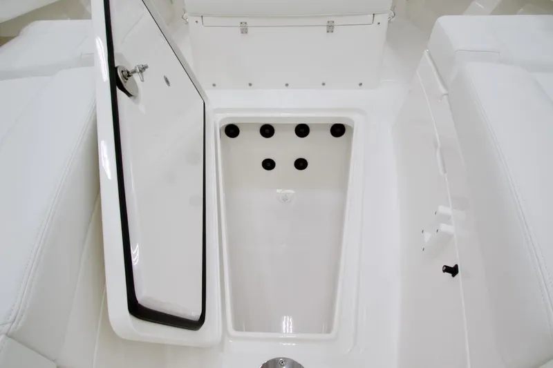 Slide: The Image of 2026 Regulator 28 boat storage compartment with open hatch, showcasing sleek white interior design. - 26