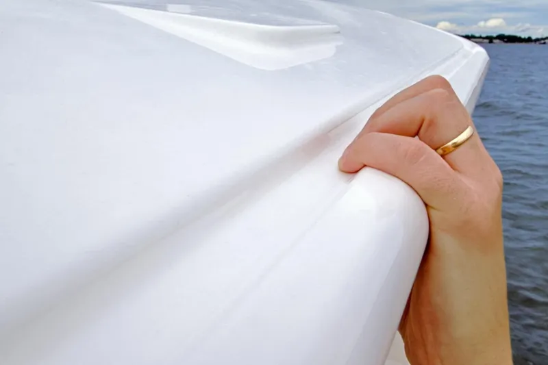 Slide: The Image of Hand gripping the side of a 2026 Regulator 28 boat on the water. - 45