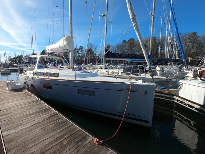 The Image of 2021 Beneteau Oceanis 38.1 sailboat docked at marina under clear blue sky. - 0