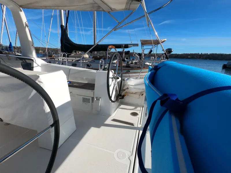 Slide: The Image of 2021 Beneteau Oceanis 38.1 yacht cockpit with steering wheel and blue fender, docked in marina. - 10