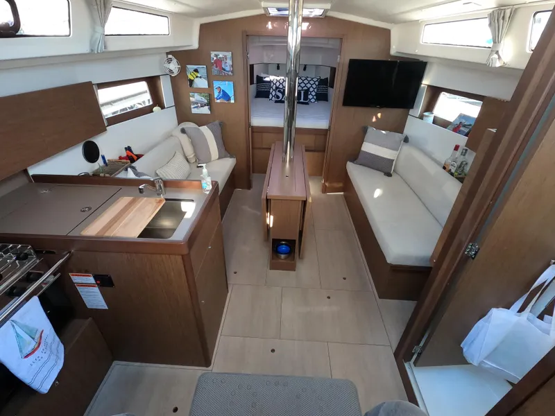 Slide: The Image of Interior of 2021 Beneteau Oceanis 38.1 yacht, featuring modern kitchen and cozy seating area. - 12