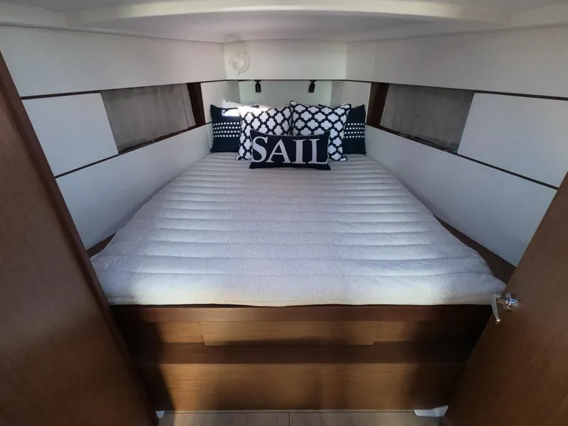 Slide: The Image of Cozy cabin interior of 2021 Beneteau Oceanis 38.1 with nautical-themed bedding. - 13