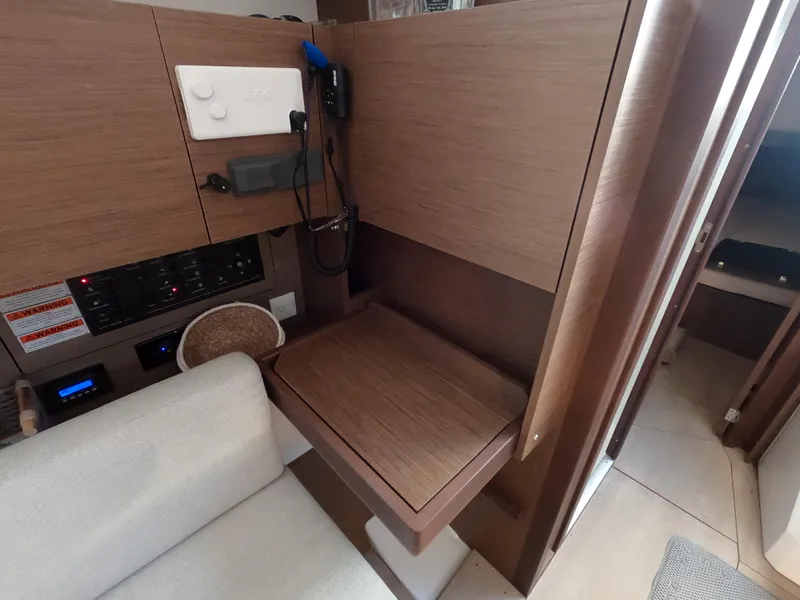 Slide: The Image of Interior of 2021 Beneteau Oceanis 38.1 yacht with wooden desk and seating area. - 27
