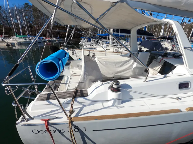 Slide: The Image of 2021 Beneteau Oceanis 38.1 sailboat docked in marina, featuring spacious deck and canopy. - 3