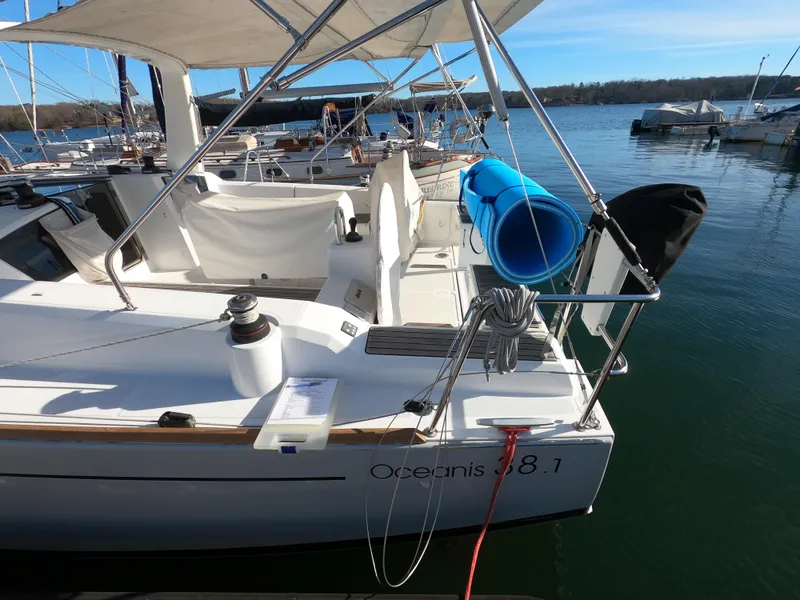 Slide: The Image of 2021 Beneteau Oceanis 38.1 sailboat docked at marina, featuring spacious deck and canopy. - 5