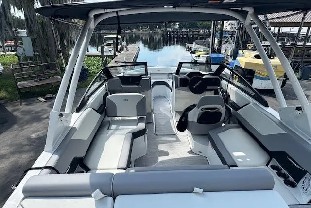 Slide: The Image of 2026 Cobalt CS23 boat interior with modern seating and sleek design at a dock. - 12