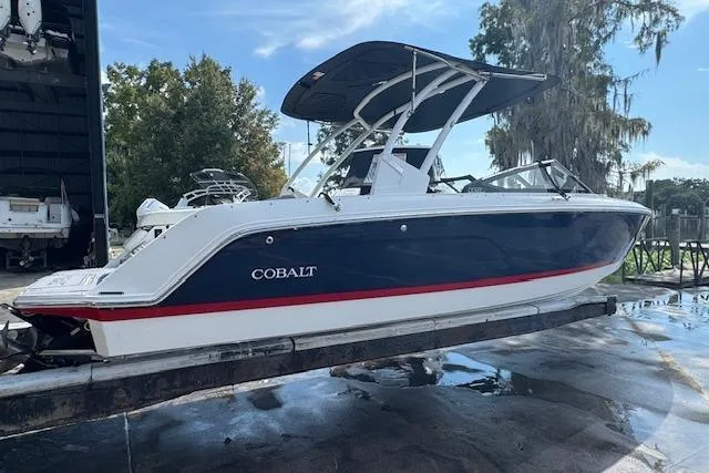 Slide: The Image of 2026 Cobalt CS23 boat with blue hull and red stripe on a trailer. - 3