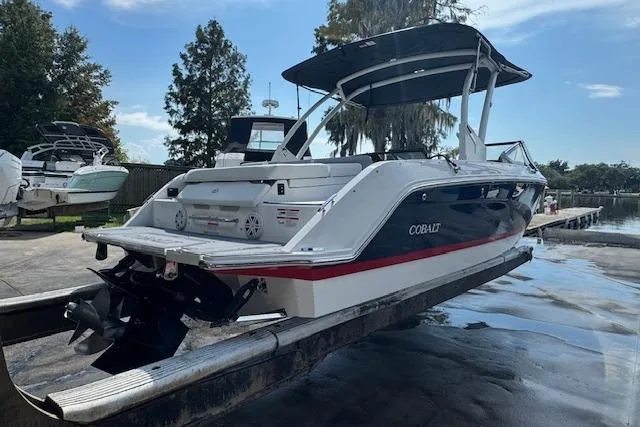 Slide: The Image of 2026 Cobalt CS23 boat on trailer, dockside, with canopy and sleek design. - 4