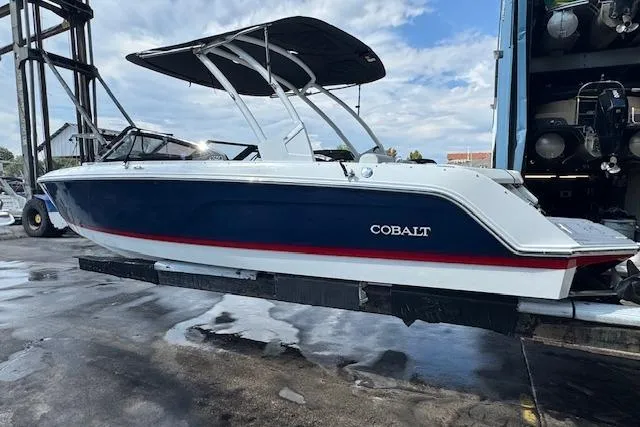 Slide: The Image of 2026 Cobalt CS23 boat with sleek design, blue hull, and red stripe, displayed on a lift. - 9