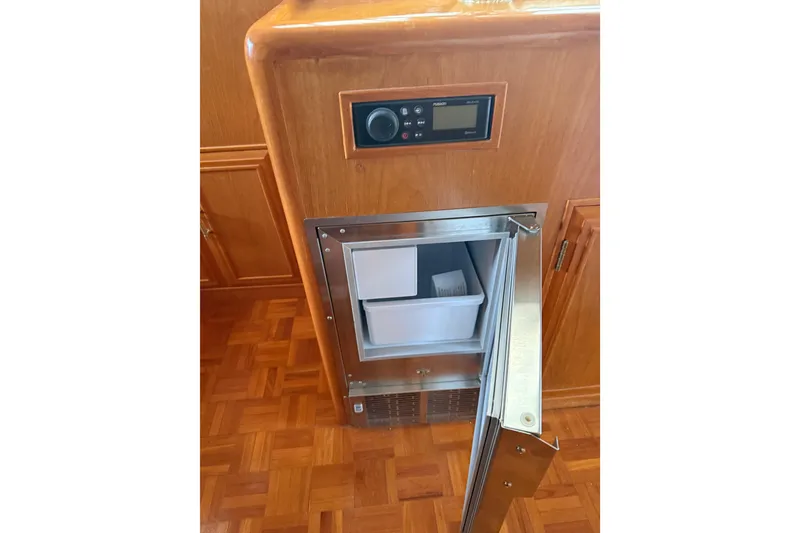 Slide: The Image of 1995 Ocean Alexander 486 yacht interior with open stainless steel refrigerator and wooden cabinetry. - 13