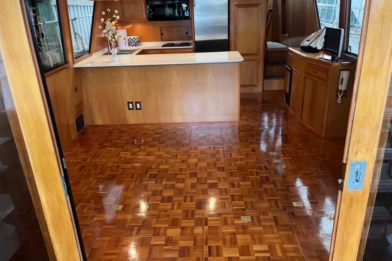 Slide: The Image of Luxurious 1995 Ocean Alexander 486 yacht interior with polished wood flooring and modern kitchen. - 18