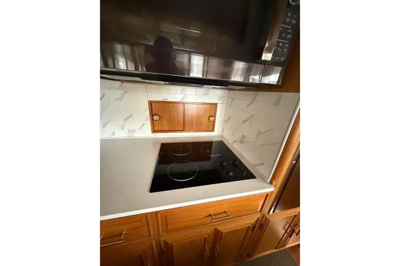 Slide: The Image of 1995 Ocean Alexander 486 yacht kitchen with modern stovetop and wooden cabinetry. - 21