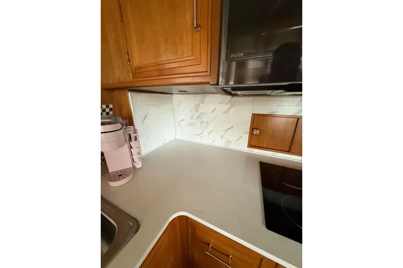 Slide: The Image of 1995 Ocean Alexander 486 yacht kitchen with wooden cabinets and modern appliances. - 22