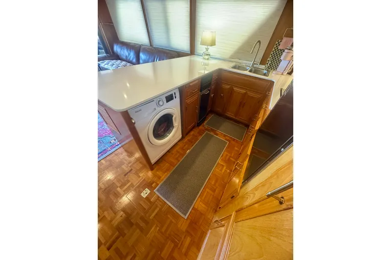 Slide: The Image of 1995 Ocean Alexander 486 yacht interior with washer, sink, and wooden cabinetry. - 23