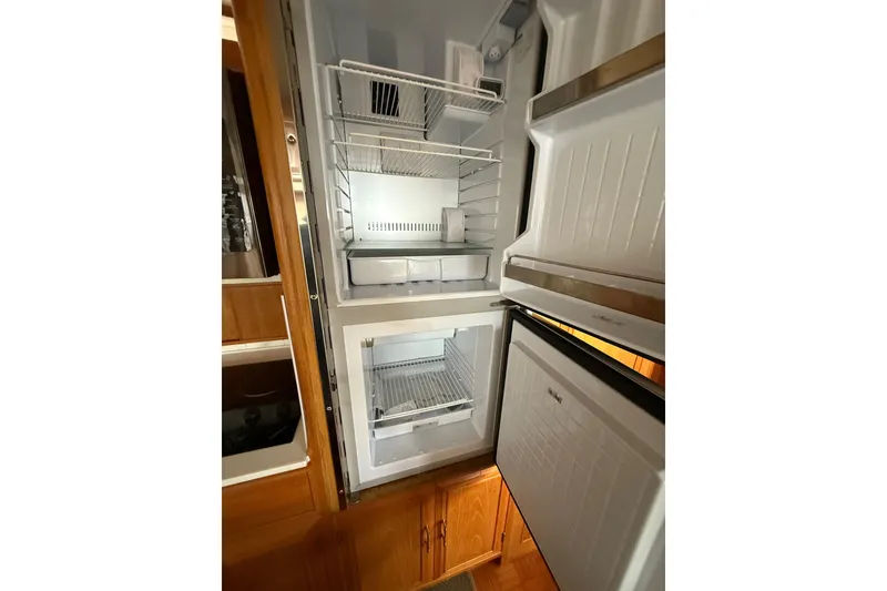 Slide: The Image of 1995 Ocean Alexander 486 yacht refrigerator with open doors and empty shelves. - 24