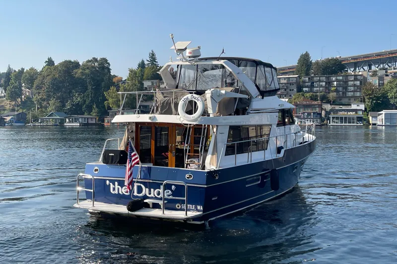 Slide: The Image of 1995 Ocean Alexander 486 yacht on a serene lake with scenic background. - 3