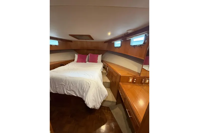 Slide: The Image of Luxurious 1995 Ocean Alexander 486 yacht bedroom with wood accents and cozy bedding. - 33