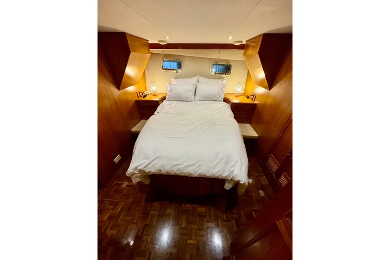Slide: The Image of Cozy bedroom interior on 1995 Ocean Alexander 486 yacht with wood accents and soft lighting. - 34