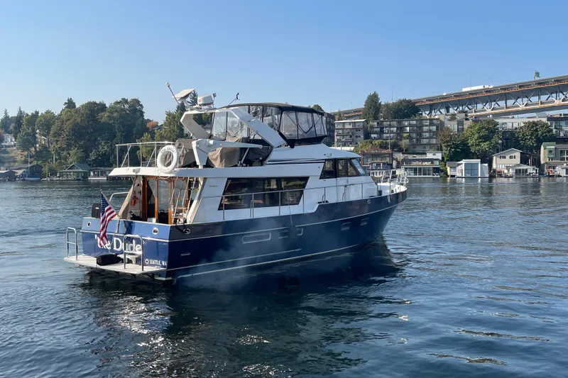 Slide: The Image of 1995 Ocean Alexander 486 yacht on calm water, with cityscape and bridge in the background. - 4