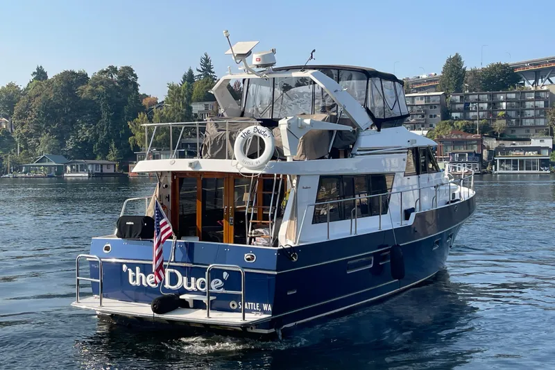 Slide: The Image of 1995 Ocean Alexander 486 yacht named "The Dude" cruising on a scenic waterway. - 5