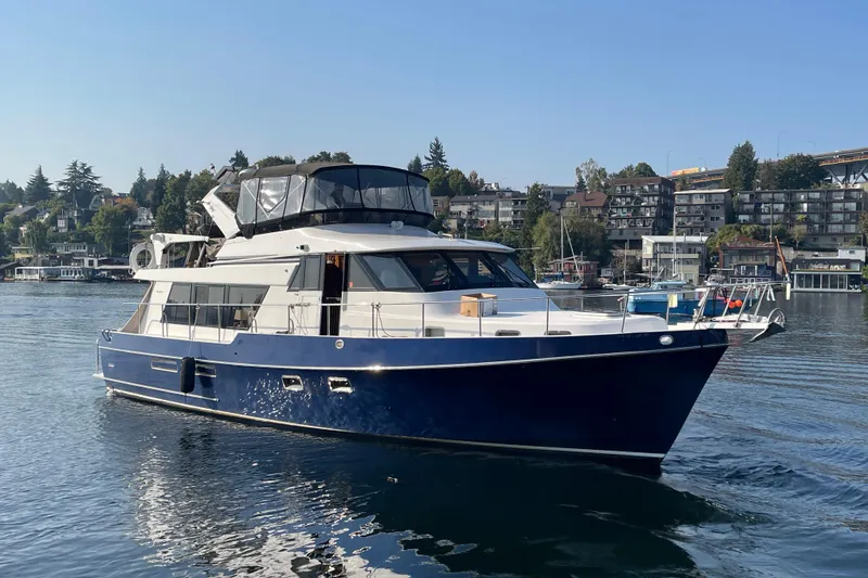 Slide: The Image of 1995 Ocean Alexander 486 yacht cruising on a calm waterfront with scenic background. - 6