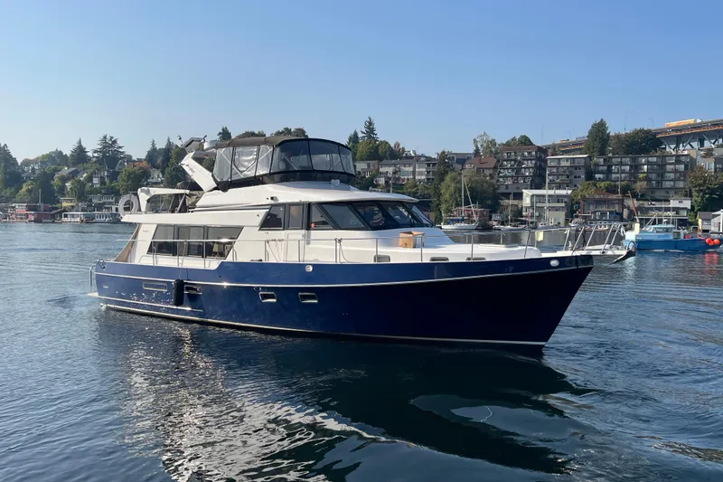 Slide: The Image of 1995 Ocean Alexander 486 yacht cruising on a calm waterfront with scenic background. - 8