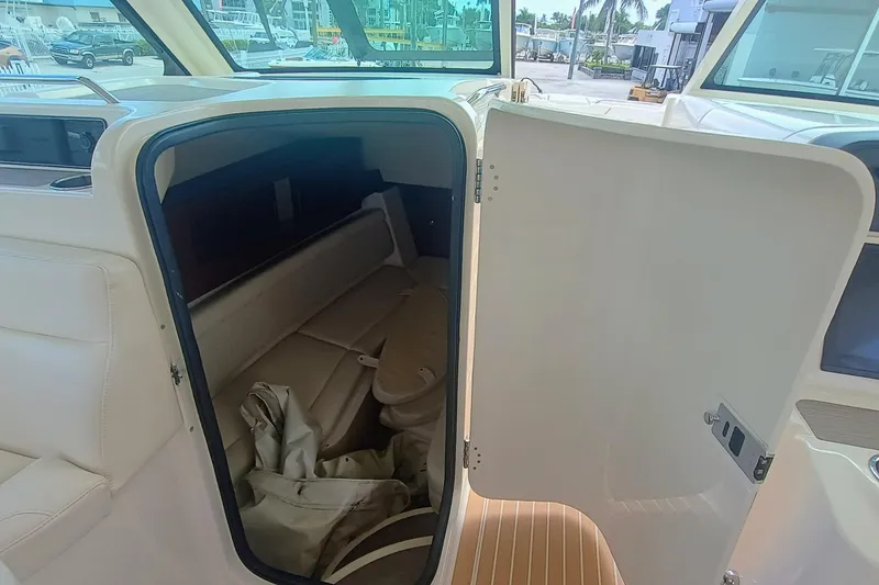 Slide: The Image of 2021 Grady-White Freedom 375 cabin interior with open door, showcasing seating and storage. - 14
