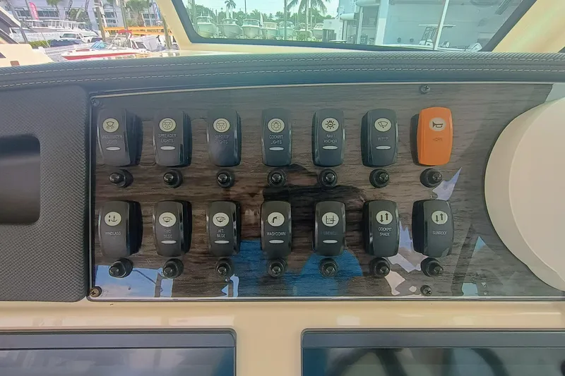 Slide: The Image of Control panel of 2021 Grady-White Freedom 375 boat with various switches and buttons. - 25