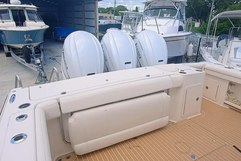 Slide: The Image of 2021 Grady-White Freedom 375 boat with triple Yamaha engines in a marina setting. - 7