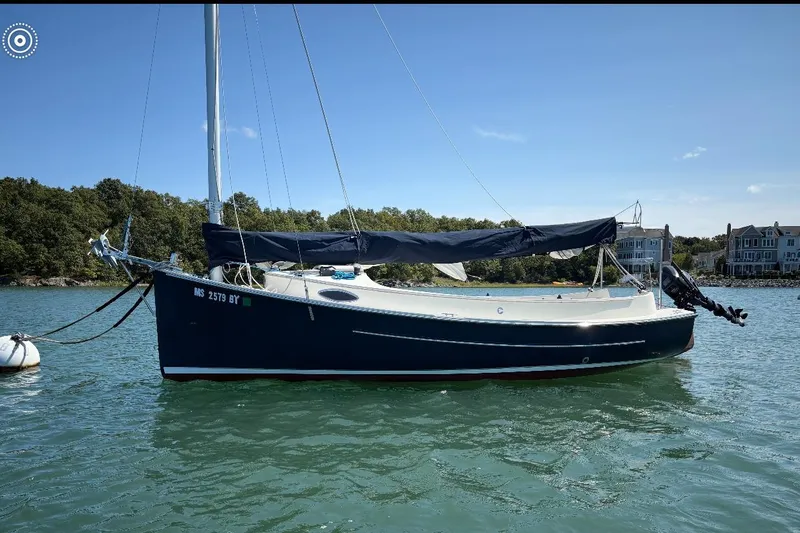 Slide: The Image of 2014 Com-Pac Horizon Day Cat sailboat on calm water, with scenic shoreline background. - 0
