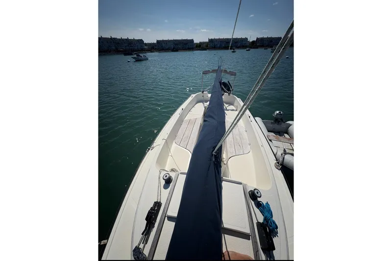 Slide: The Image of 2014 Com-Pac Horizon Day Cat sailboat on calm water, docked near shore. - 1