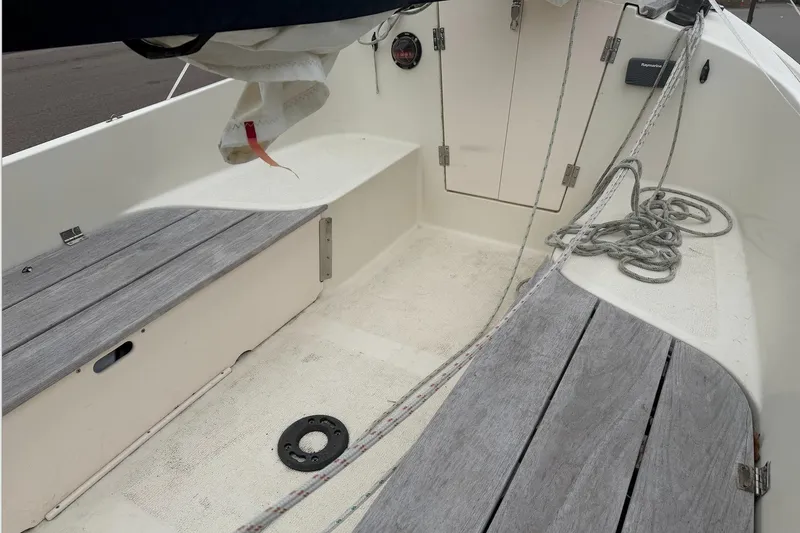 Slide: The Image of 2014 Com-Pac Horizon Day Cat sailboat cockpit with wooden benches and coiled ropes. - 14