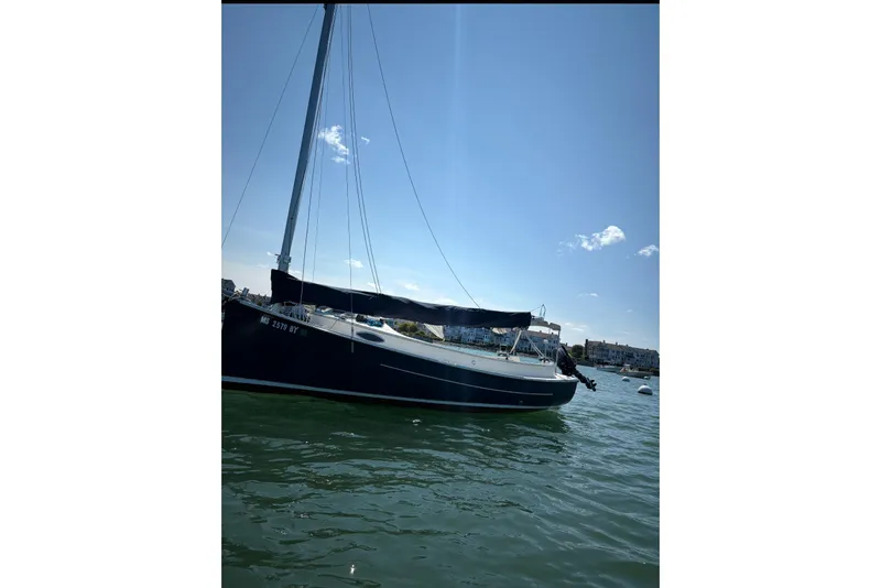 Slide: The Image of 2014 Com-Pac Horizon Day Cat sailboat on calm water under clear blue sky. - 2