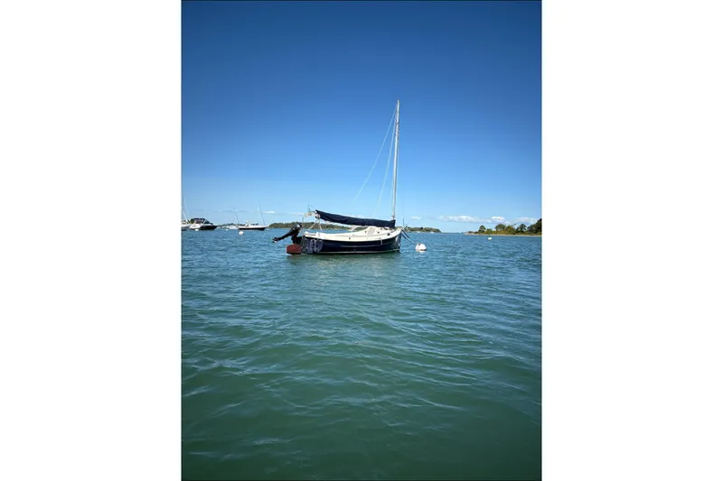 Slide: The Image of 2014 Com-Pac Horizon Day Cat sailboat on calm blue water under clear sky. - 5