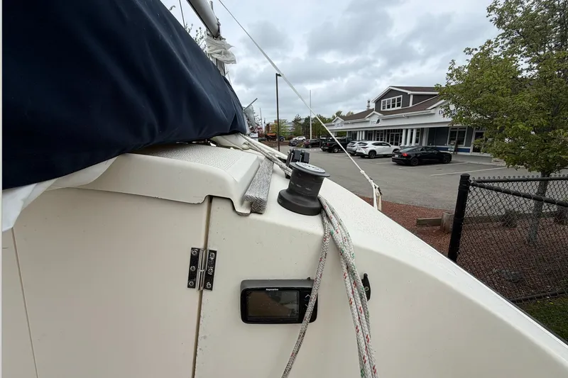 Slide: The Image of 2014 Com-Pac Horizon Day Cat sailboat with ropes, docked near a parking lot. - 8