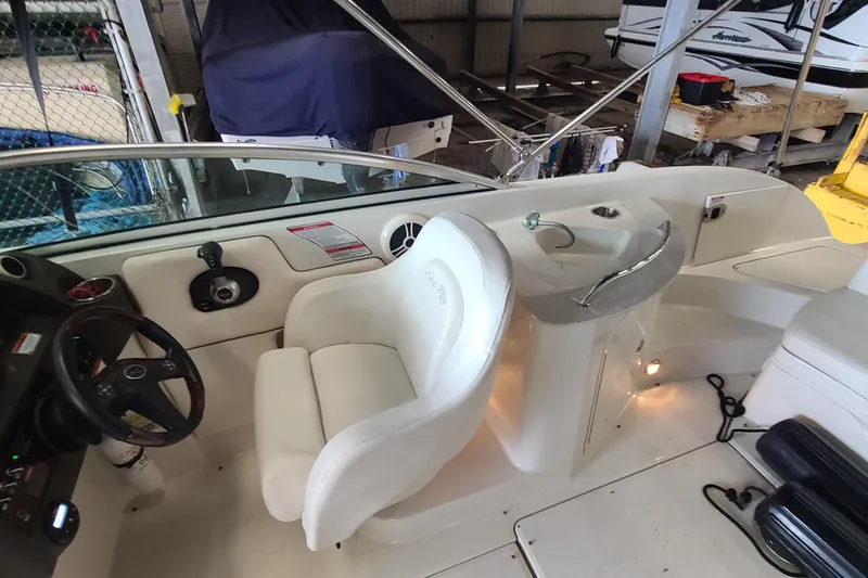 Slide: The Image of 2008 Sea Ray 260 Sundeck interior with helm, seating, and sink in a storage area. - 12