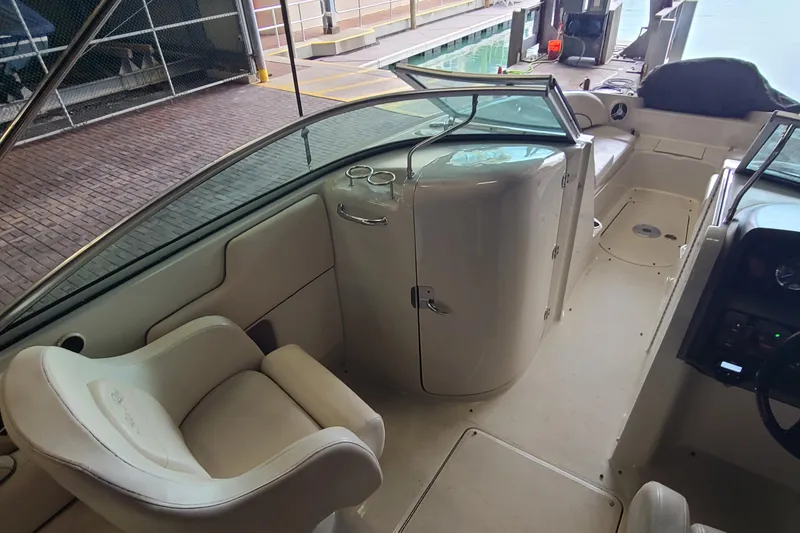 Slide: The Image of 2008 Sea Ray 260 Sundeck interior with seating and storage, dockside view. - 17