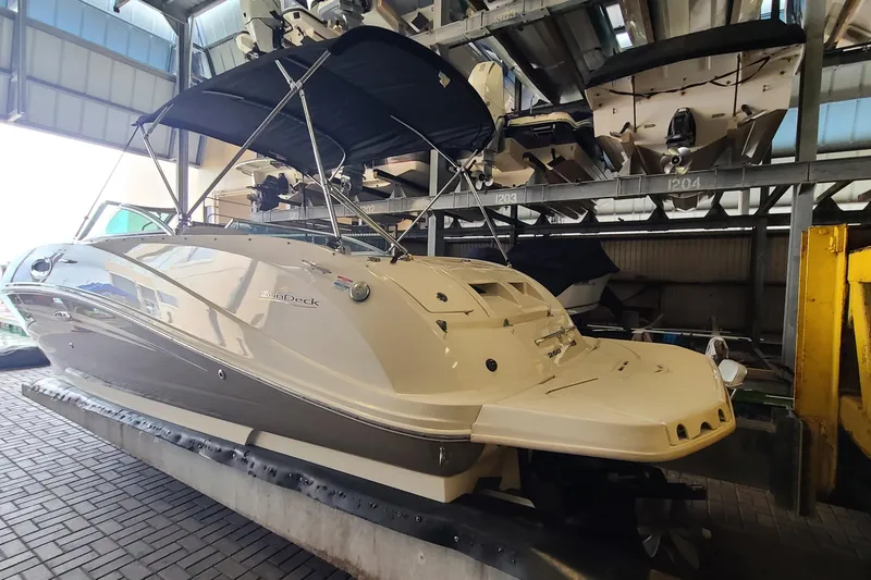 Slide: The Image of 2008 Sea Ray 260 Sundeck boat in storage, featuring sleek design and canopy. - 2