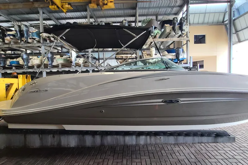 Slide: The Image of 2008 Sea Ray 260 Sundeck boat in storage, featuring sleek design and black canopy. - 6