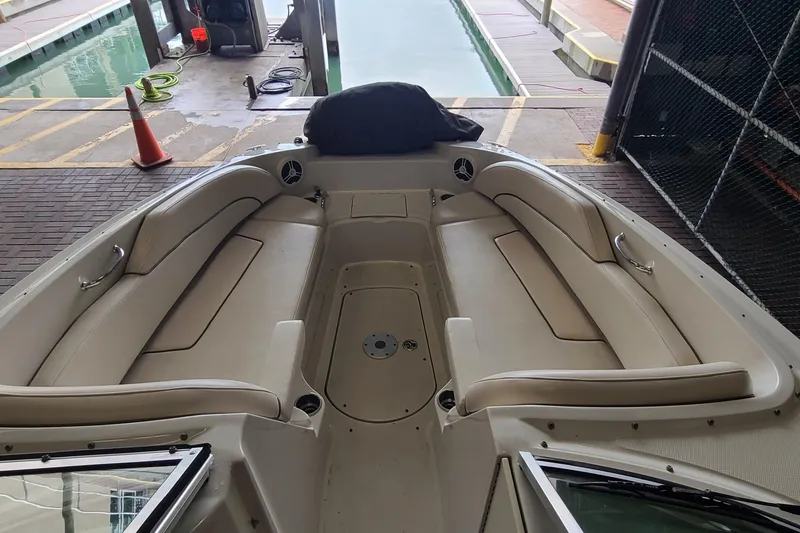 Slide: The Image of 2008 Sea Ray 260 Sundeck interior with beige seating, docked in a marina. - 8