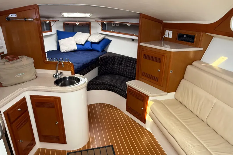 Slide: The Image of Interior of 2001 Cabo 35 Express yacht with cozy seating and compact kitchenette. - 1