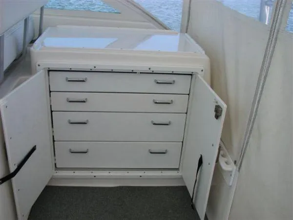 Slide: The Image of 2001 Cabo 35 Express boat interior with open storage cabinet and drawers. - 15