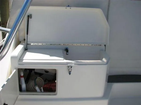 Slide: The Image of 2001 Cabo 35 Express boat storage compartment with open lid and visible equipment. - 16