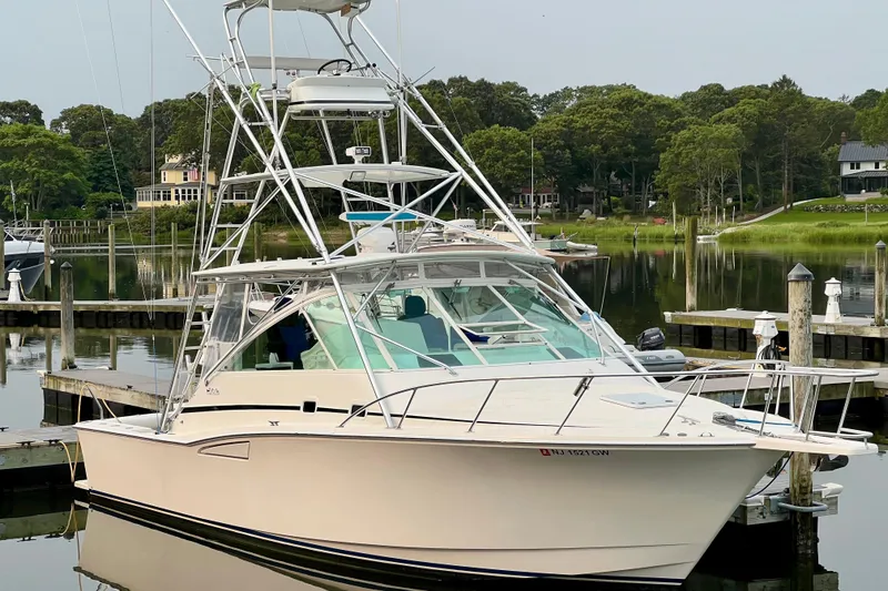 Slide: The Image of 2001 Cabo 35 Express boat docked in a serene marina setting. - 3