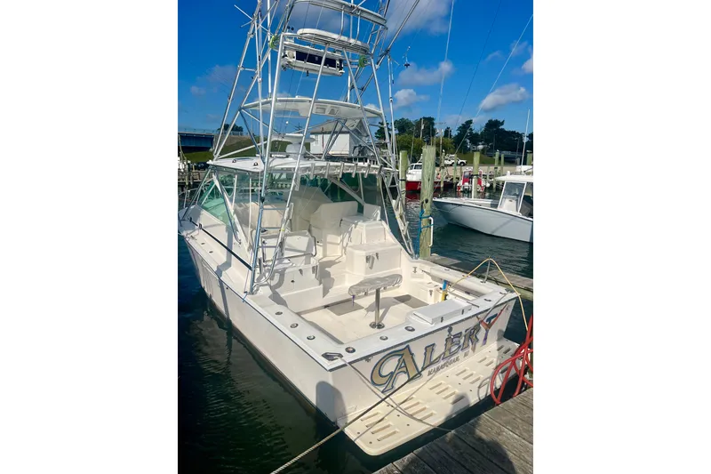 Slide: The Image of 2001 Cabo 35 Express boat docked at marina under clear blue sky. - 33