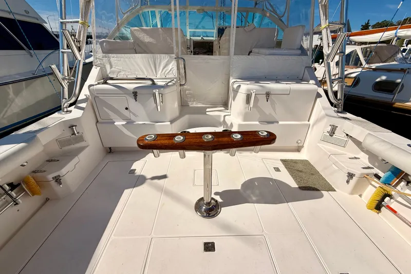 Slide: The Image of 2001 Cabo 35 Express boat deck with fishing rod holders and seating area. - 36